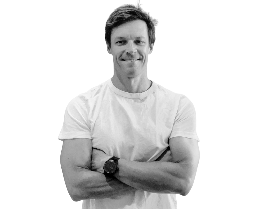 Black and white photo of a person wearing a white t-shirt with arms crossed.